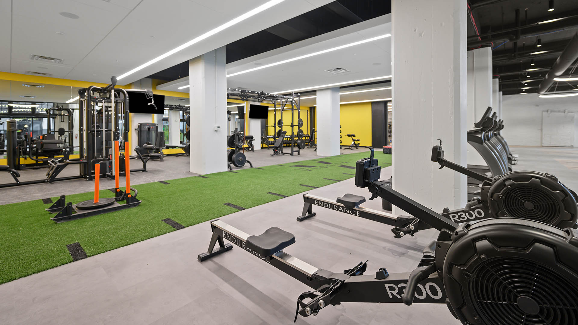 Fitness center with artificial turf and rowing machines.